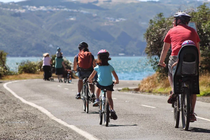 Families walking and biking along the Miramar Peninsula coastal road. 