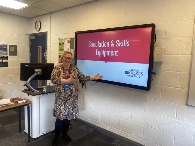 Image of a member of staff in front of a teaching screen with the slide "Simulation and Skills Equipment" displayed. 