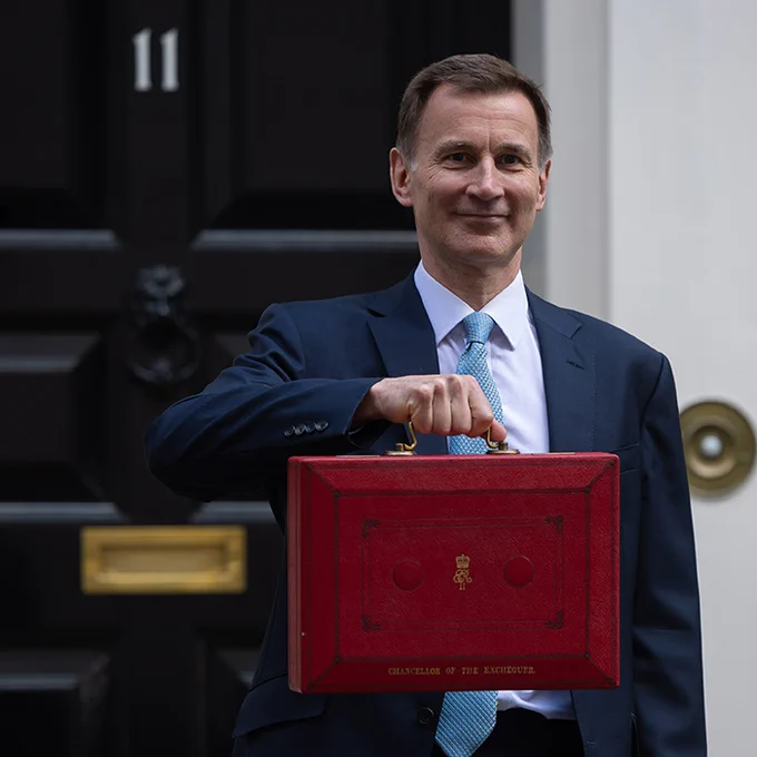 This image depicts Chancellor Jeremy Hunt standing outside Number 10 Downing Street holding the Ministerial Red Box.
