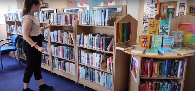 A reader browsing the shelves of Blantyre Library.