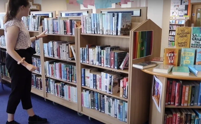 Young person browsing the library books in a colourful display. 