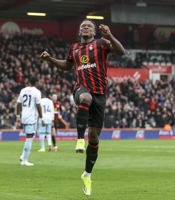 Luis Sinisterra celebrates by jumping in the air at Vitality Stadium.