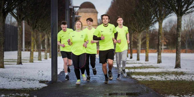 Members of Street League running in park.