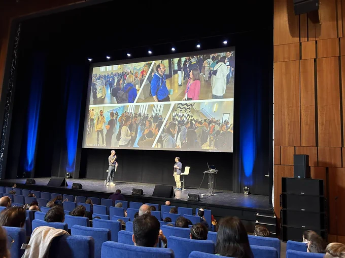Those two speakers on the stage. Behind them picture of some people at flow con from yesterday.