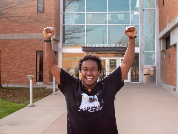 Student with his arms in the air.
