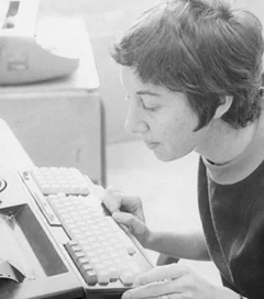 B&W photo of Judith Clapp working on a keyboard.