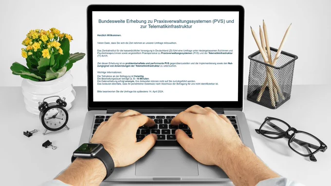 Ein Mann sitzt vor einem Laptop und tippt etwas ein. Der Bildschirm zeigt die Startseite der Umfrage zum PVS.