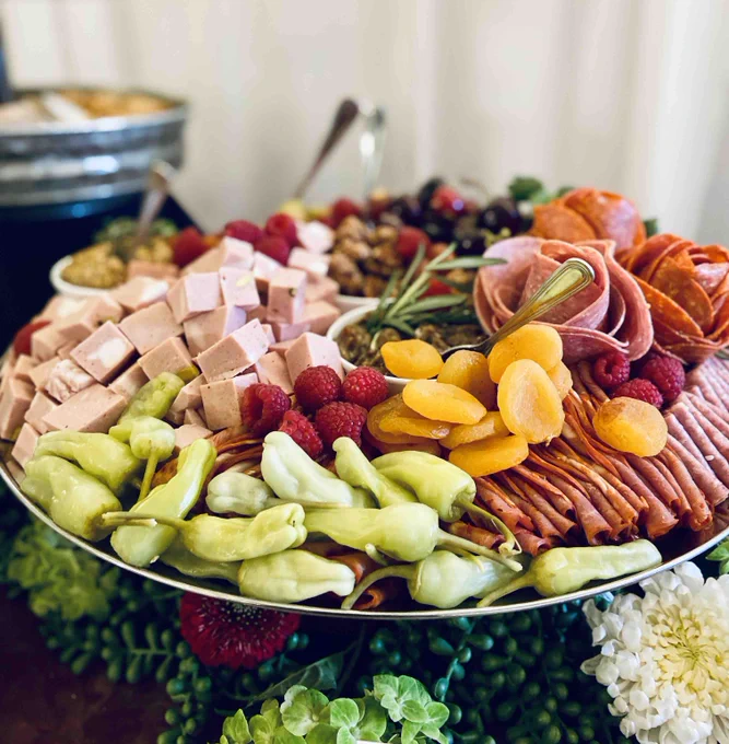 Colorful charcuterie display with salami, mortadella, pepperoni, peppers, dried apricots and olives