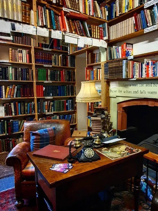 Image Description: A desk and leather armchair surrounded by shelves of books
