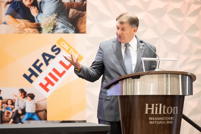 Senator Mike Rounds speaking at the NCSHA 2024 Legislative Conference with #HFAsOnTheHill sign in the background