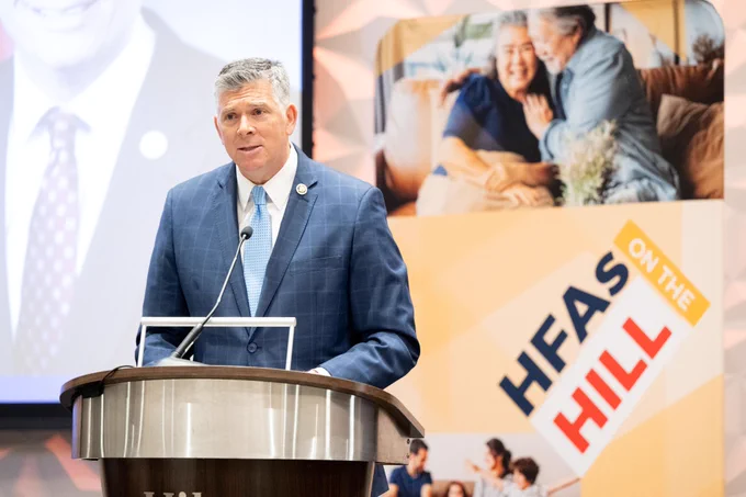 Representative Darin LaHood speaking at the NCSHA 2024 Legislative Conference with #HFAsOnTheHill sign in the background