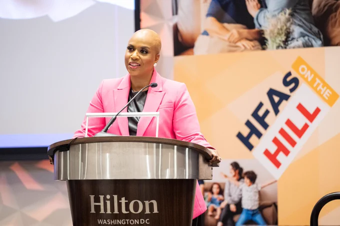 Representative Ayanna Pressley speaking at the NCSHA 2024 Legislative Conference with #HFAsOnTheHill sign in the background