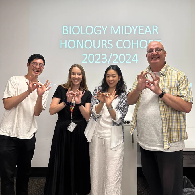 Four people standing in front of a background that reads "BIOLOGY MIDYEAR HONOURS COHORT 2023/2024".