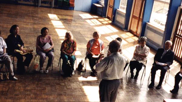 An image of a group of people sitting in a semi circle