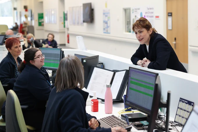 Victoria Atkins talking to reception team members at Heatherwood Hospital.