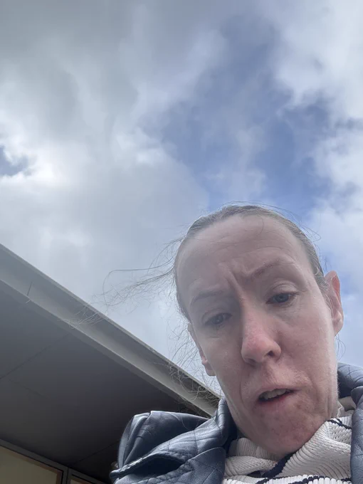 A photo of me looking down at my phone  outside my polling station
