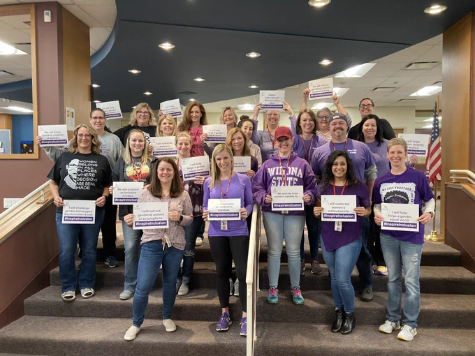 HMS staff poses with #InspireInclusion signs
