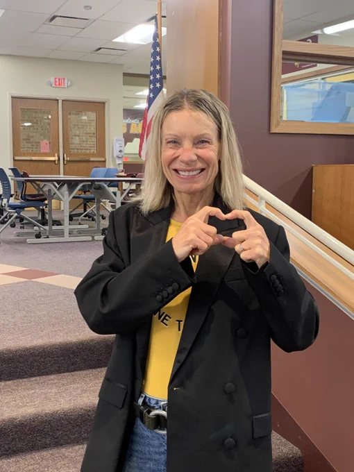 Teacher makes heart with hands