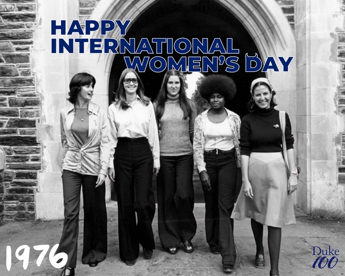 A different photo of five women walking under the same stone archway at Duke. The year 1976 is written in the corner with the text "happy international women's day" at the top