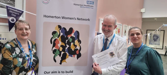 Women's Network Leads & IT Director all smiling alongside the network's logo banner.