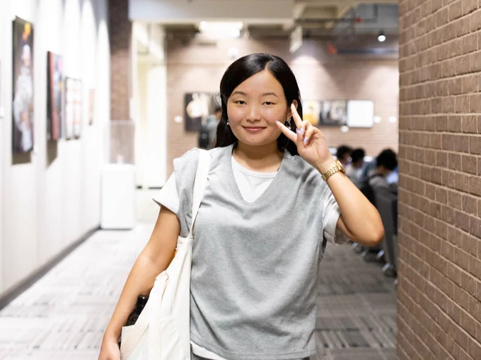 Smiling student throwing a peace sign.