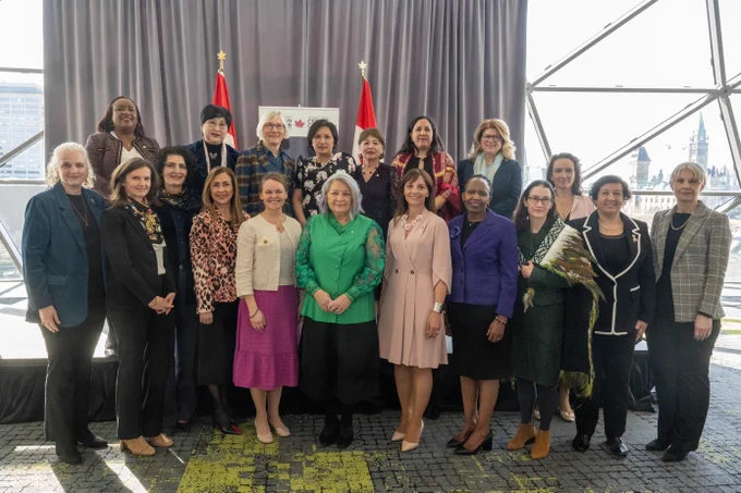 Governor General Simon standing in the center of a group of women posing for a group photo.
