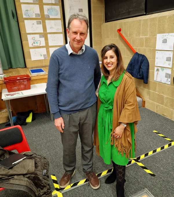 2 people standing in front of a stage at the Benson Nature event. On the left is Dr Bird (a GP), tagged, and to the right is Geeta. 