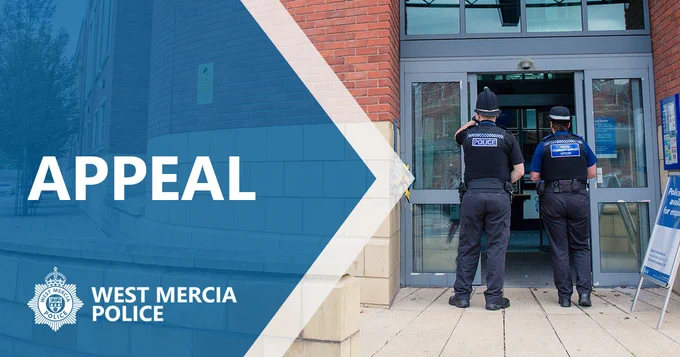 Male and female officers facing police station. 