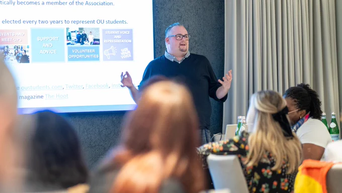 The image shows Gareth Jones, Deputy President of the Students Association Student Leadership Team, presenting to the room.