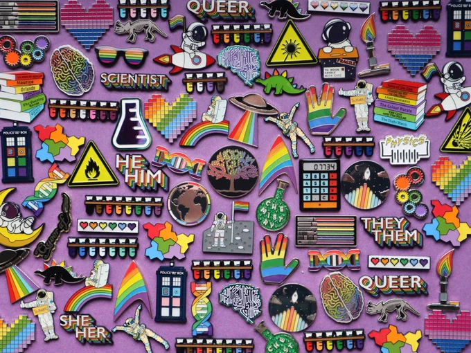 Lots of science themed rainbow pin badges 