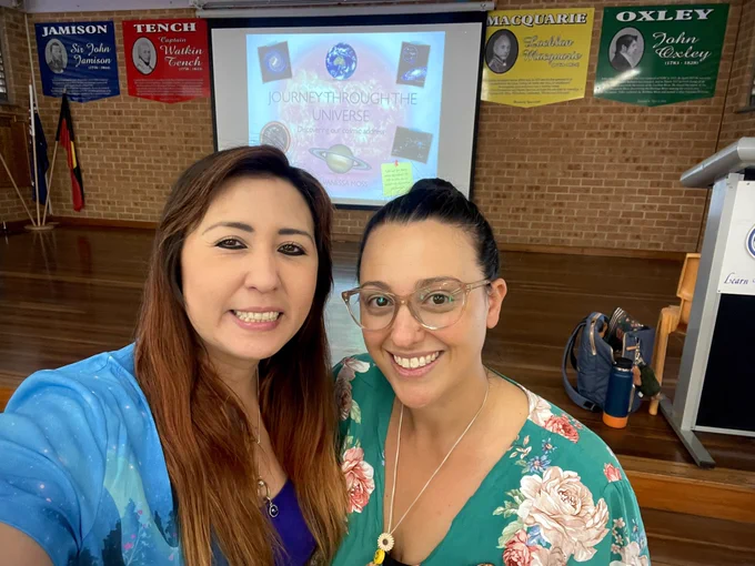 Two smiling happy basketball players dressed in normal clothes for their “real jobs” with Vanessa visiting the school to give a talk about space and astronomy 🪐
