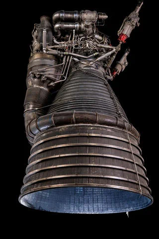 close-up vertical photo shows a complex rocket engine with the circular opening pointed down.