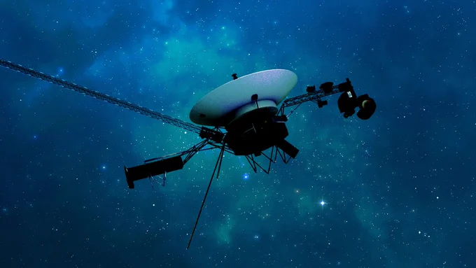 An illustration of Voyager 1 traveling through interstellar space, or the space between stars. The Voyager spacecraft sits against a stunning blue hazed background peppered with thousands of white dots representing distant stars. Voyager's white high-gain antenna dish is facing upward toward the stars. Other antenna and instruments our outlined around the dish, fading into the vastness of space. 