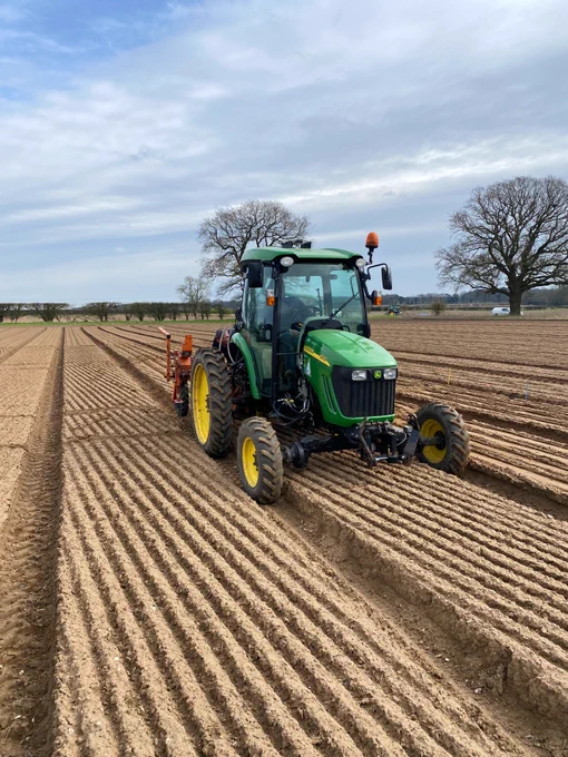 A tractor in a bare field - NIAB staff drilling an onion variety trial in Norfolk.