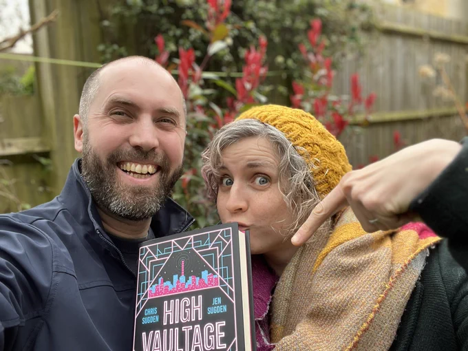Chris and Jen Sugden, holding up a hardback copy of High Vaultage