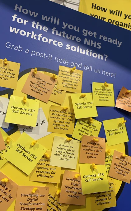 Yellow post-it notes with messages on the Digital Workforce Solution, cover a panel of the NHSBSA exhibition at Digital Health Rewired in Birmingham.