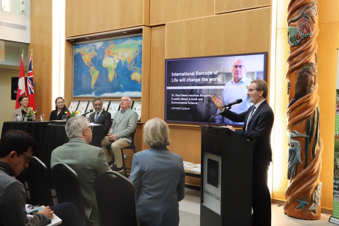 A man speaks to a crowd at a podium.