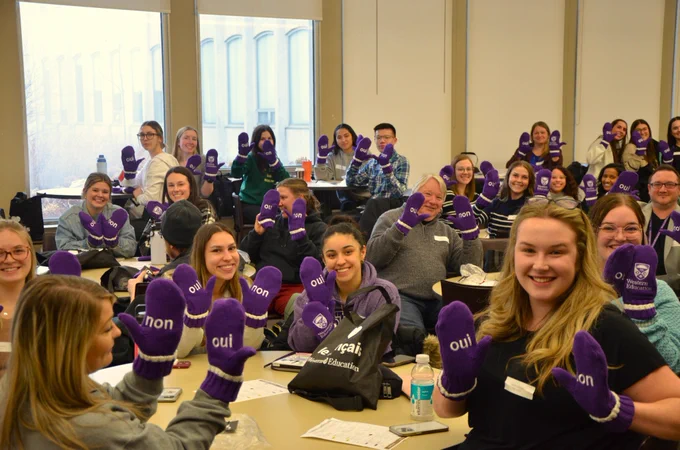 Attendees pose for a photo while holding custom-made French as a Second Language (FSL) Western Education mittens.
