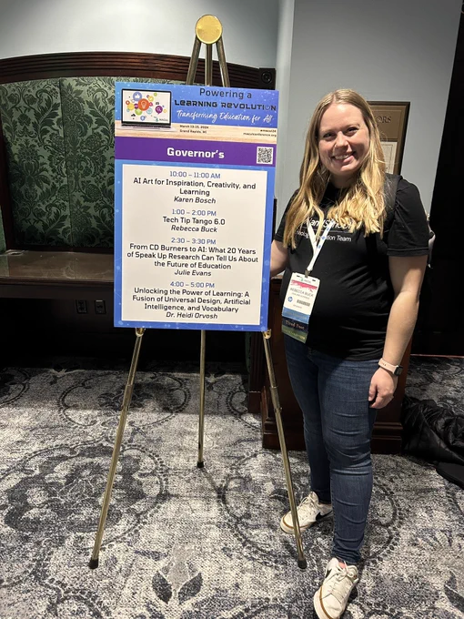 Becca standing with the session list sign for the governors room