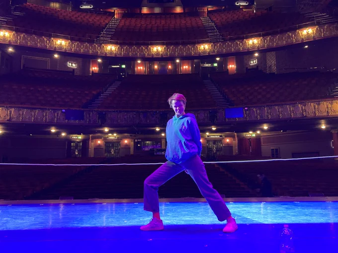 Hannah Barrie standing onstage at the Palace Theatre, Manchester - bathed in wonderful blue light!