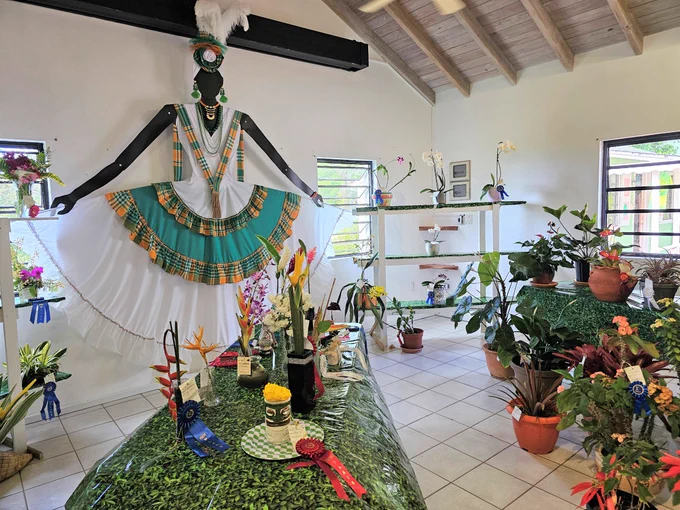 A room filled with potted and cut flowers, and cultural displays