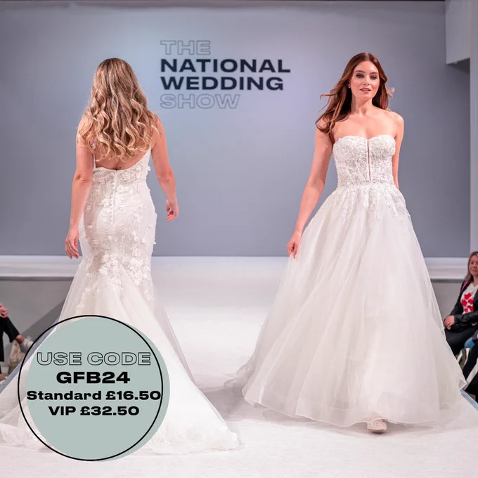 Image depicts two people walking down the catwalk at The National Wedding Show wearing wedding dresses. 