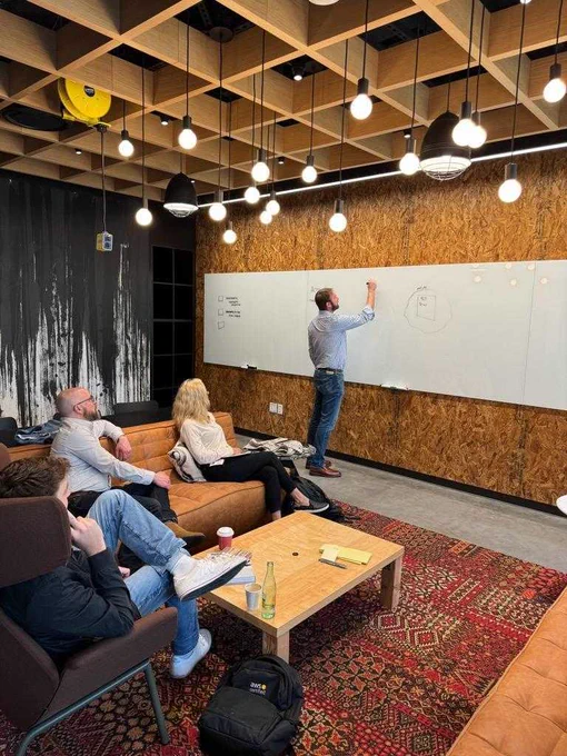Jeff Thorn at the white board as Thorn Tech and AWS team members look on.