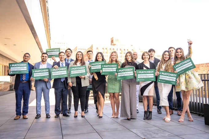Group of medical students holding Match Day signs outside in Detroit