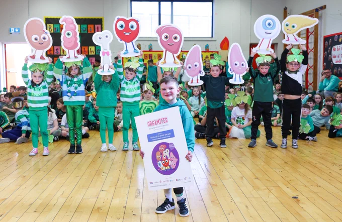 Dáithí and his classmates launching new organ donation resources in the Irish language. Dáithí is in front with the cover of the new resources while his classmates holds the Orgamites behind him.