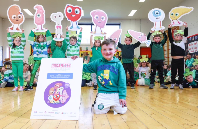 Dáithí and his classmates launching new organ donation resources in the Irish language. Dáithí is in front with the cover of the new resources while his classmates holds the Orgamites behind him.