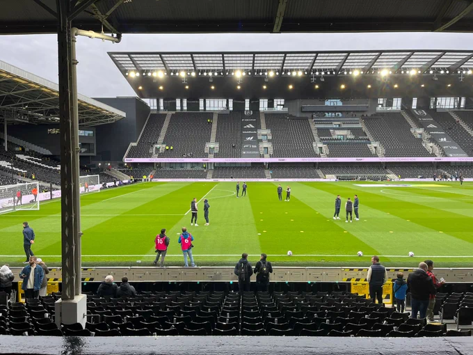 Photo of Craven Cottage pitch with team staff chatting before the game