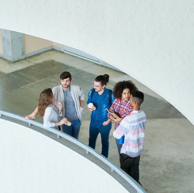 University students stood chatting in the university foyer.