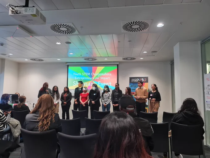 Picture of a group of young people standing in front of everyone making a presentation 