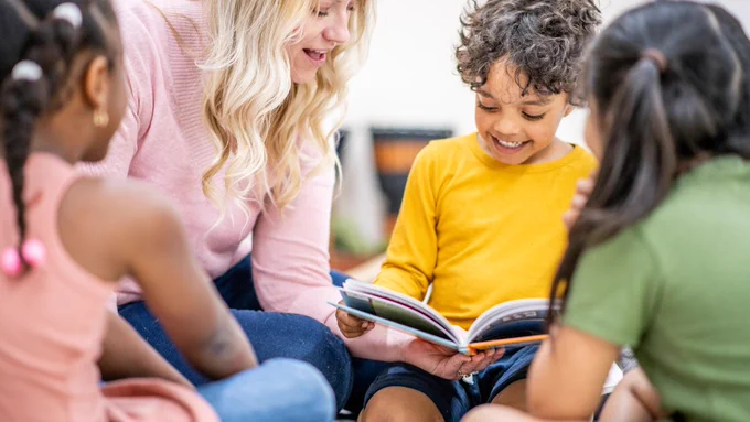 Young boy reads a book in class.